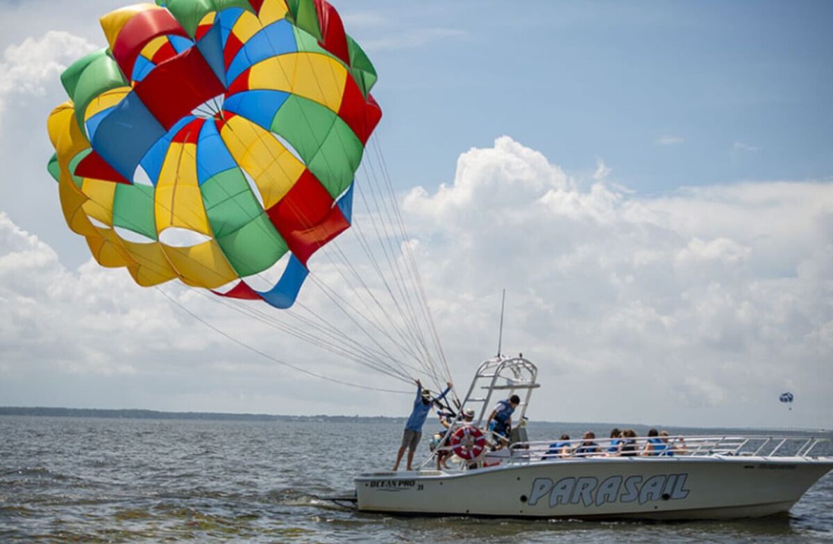 Rainbow parasail lifting off behind the Parasail boat on the Currituck Sound