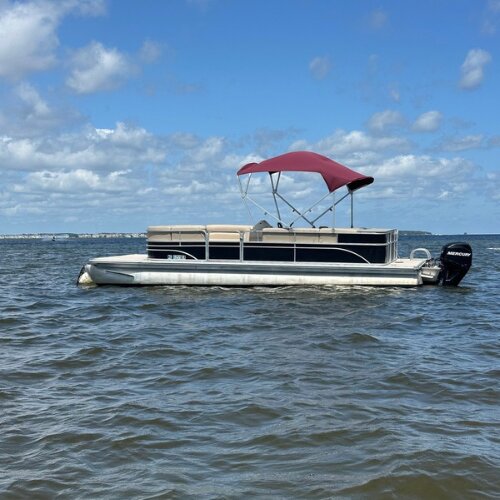 Pontoon boat with red bimini top anchored on the sound