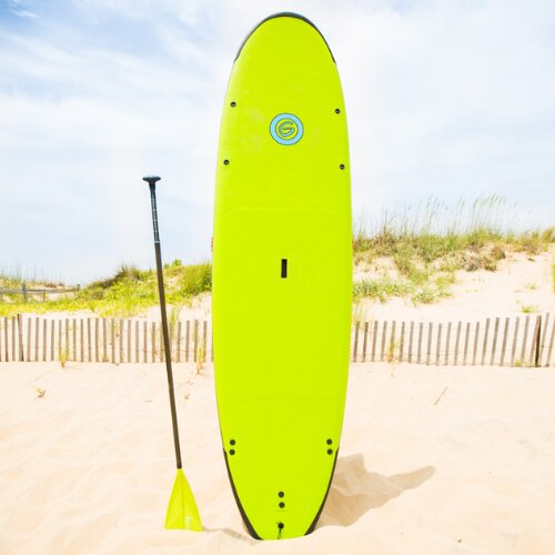 Bright green standup paddleboard and paddle by the dunes